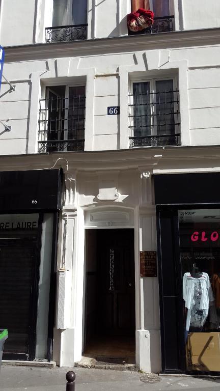 a white building with two entrances to a store at Hôtel Cyrano Voltaire in Paris