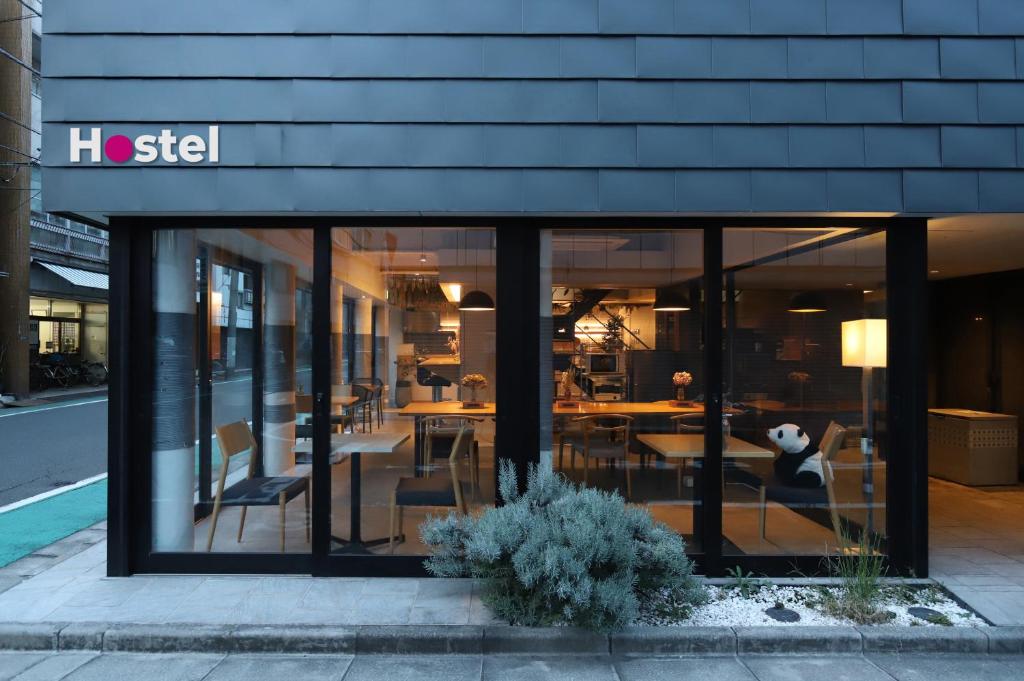 a restaurant with tables and chairs in a building at E10 Hostel in Tokyo