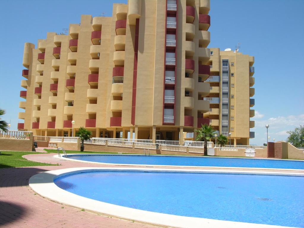un edificio con piscina frente a un edificio en Los Miradores Del Puerto - 3207, en La Manga del Mar Menor