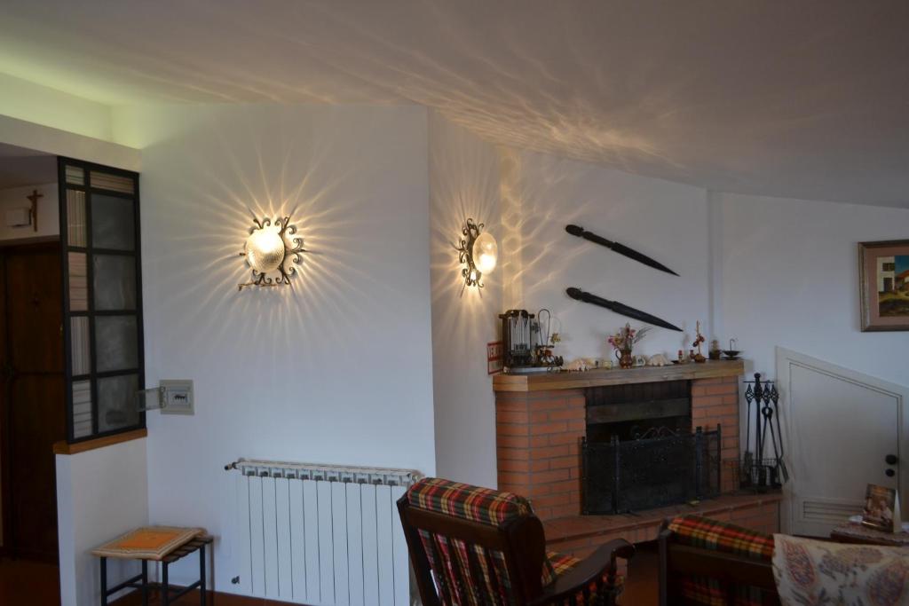 een woonkamer met een open haard en 2 lampen aan de muur bij Apartment De Gasperi in Serrone
