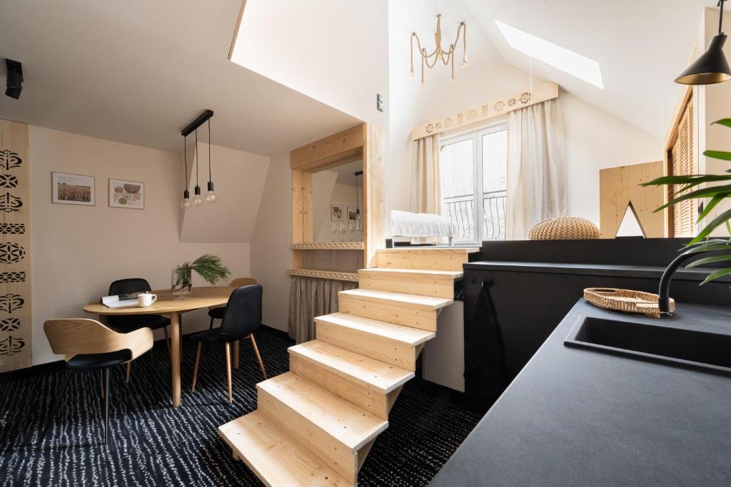 a staircase in a room with a table and chairs at Willa Dunajec in Zakopane
