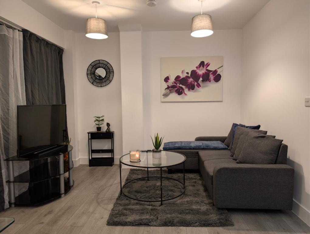 ein Wohnzimmer mit Sofa und Tisch in der Unterkunft Hemel Apartments - Hemel Haven in Hemel Hempstead
