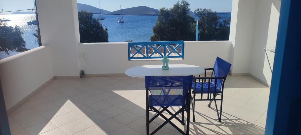 a table and chairs on a balcony with a view of the water at Filina's Studio Corner in Maltezana