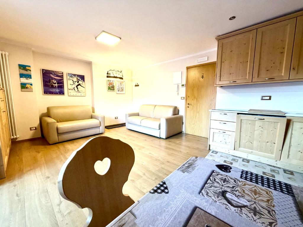 een woonkamer met een bank en een tafel bij EMARGHE, CASA A MOENA in Moena