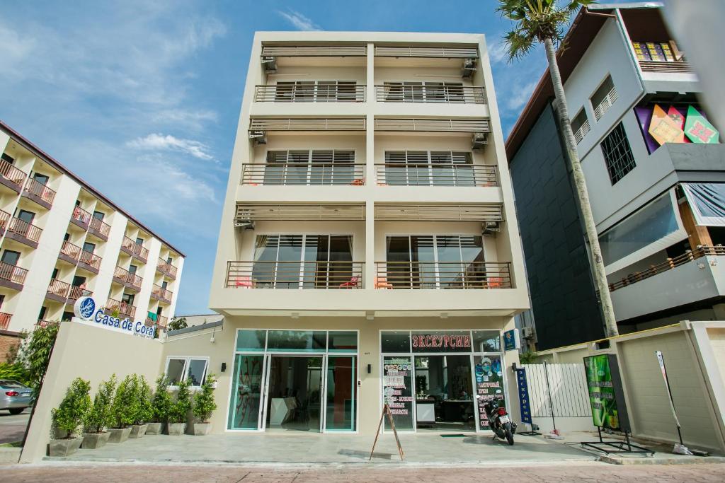a tall white building with a lot of windows at Casa De Coral Boutique Hotel in Kata Beach