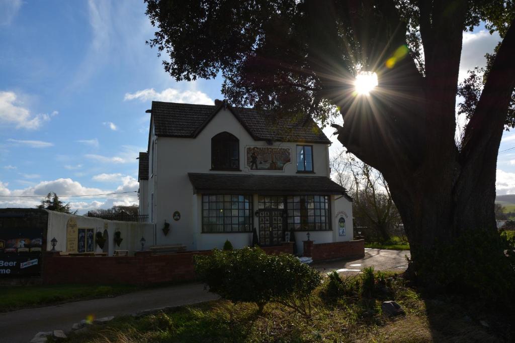 a white house with the sun shining on it at The Smugglers Inn in Minehead