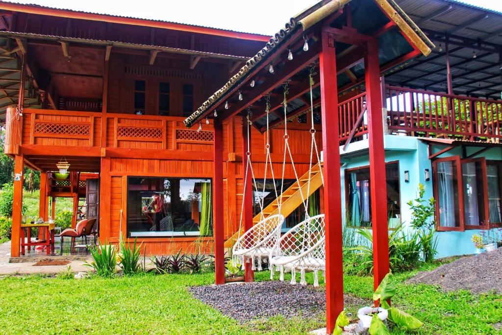 a house with a porch and a swing at Villa Lokon Tomohon in Tomohon