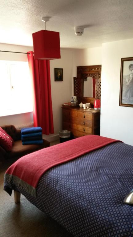 a bedroom with a bed and a red curtain at Podehole Bed and Breakfast in Spalding