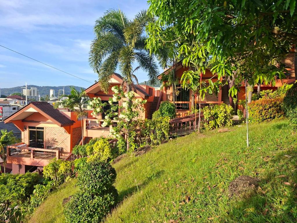 a house on top of a grassy hill at The Cozy House in Karon Beach