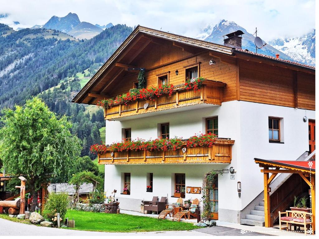 a house in the mountains with flowers on the balcony at Fewo-Egger-Thalmann in Virgen