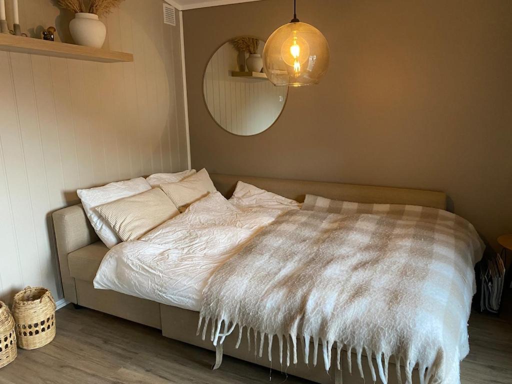 a bed with a white comforter in a bedroom at Furnishe outhouse in Bergen