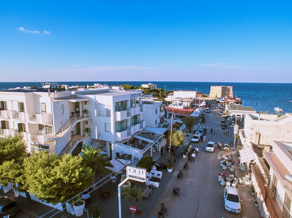 a city street with buildings and the ocean in the background at Hotel Cicò in Torre Santa Sabina