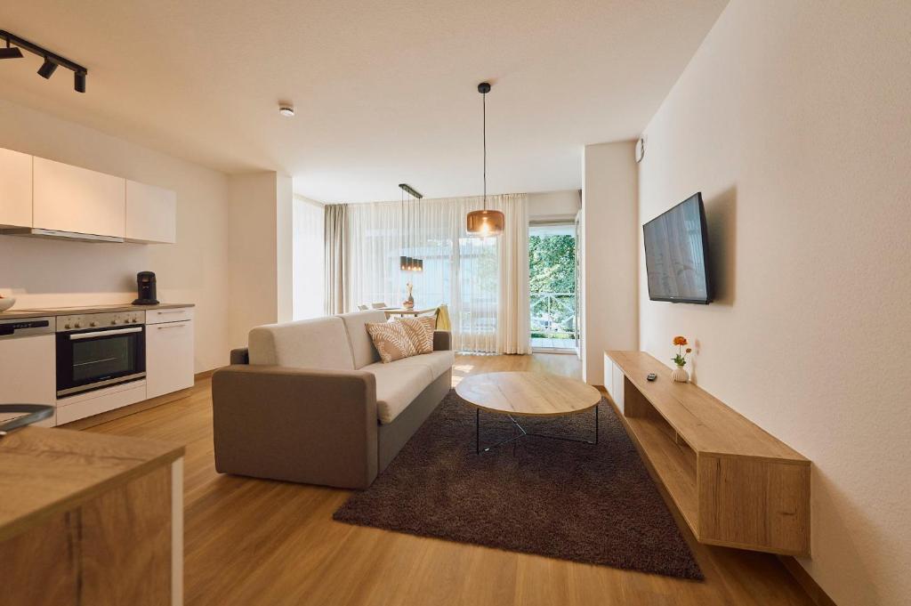 een woonkamer met een bank en een tafel bij Kapfwald Appartements in Bad Dürrheim