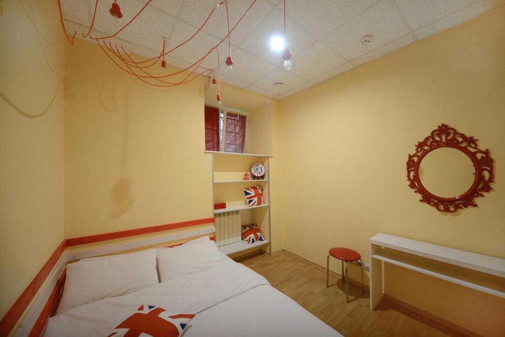 a small bedroom with a bed and a mirror at Good Dreams Hostel in Kyiv