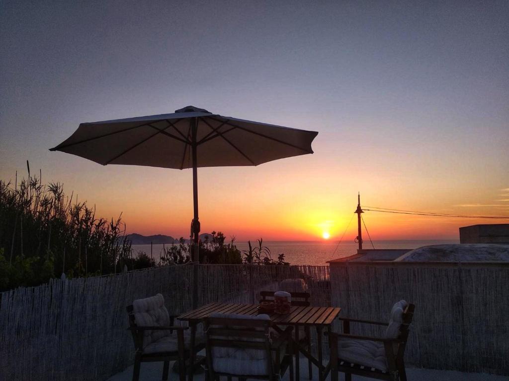 un tavolo con ombrellone davanti al tramonto di Ponzamania Casa Silvana Ponza a Ponza