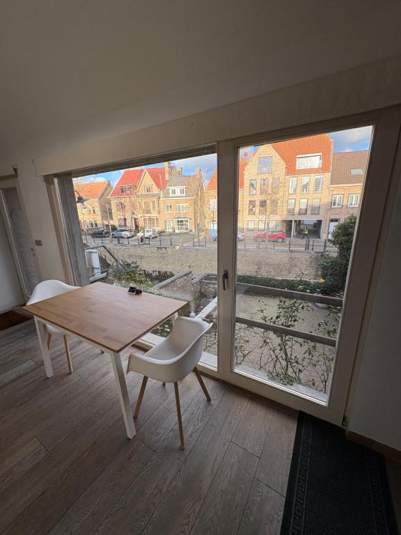 a room with a table and a large window at Belle Nuit in Diksmuide