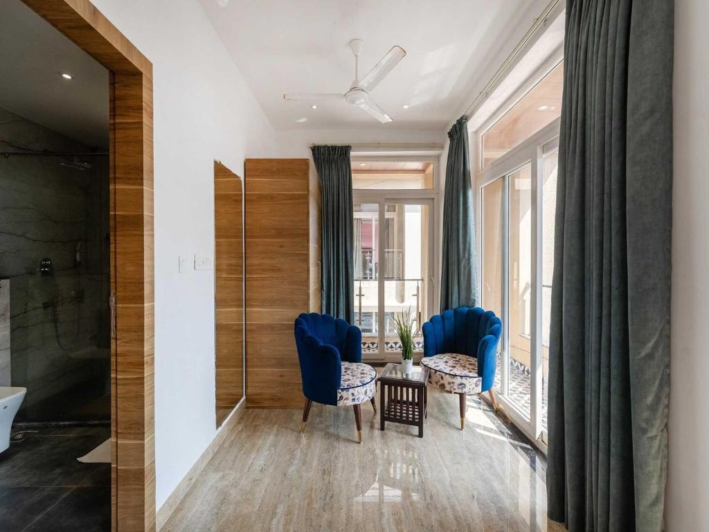 a bathroom with blue chairs and a table and a tub at Villa Vana By DanCenter | 5BHK | Pvt Pool | Baga Beach, GOA in Arpora