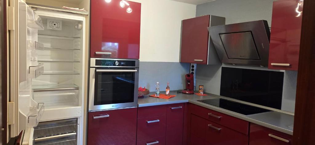 een keuken met rode kasten en een open koelkast bij Berg Messe 1, w-lan, Homeoffice in Bergisch Gladbach