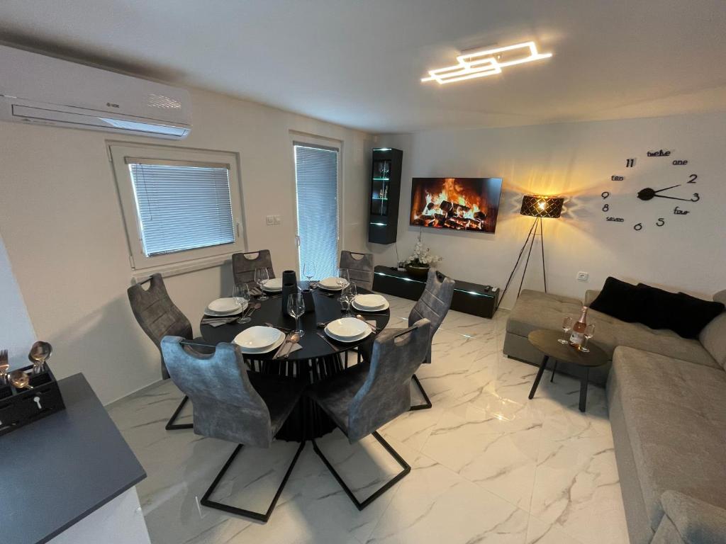 a living room with a table and chairs and a couch at Second home apartment - silver in Kustići
