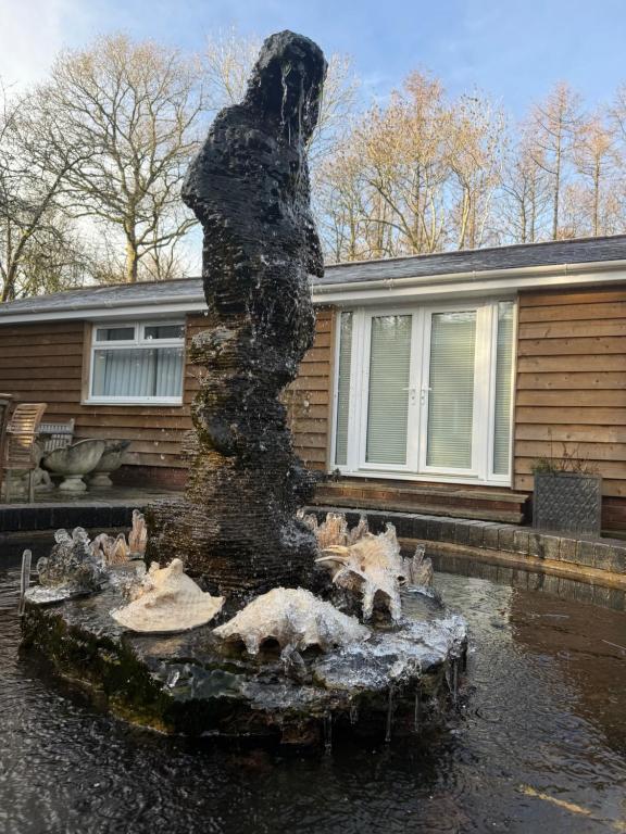 een standbeeld van een persoon die bovenop een fontein staat bij Dorset Getaway Hot Tub and Alpacas Relaxing UK Short Break in Horton