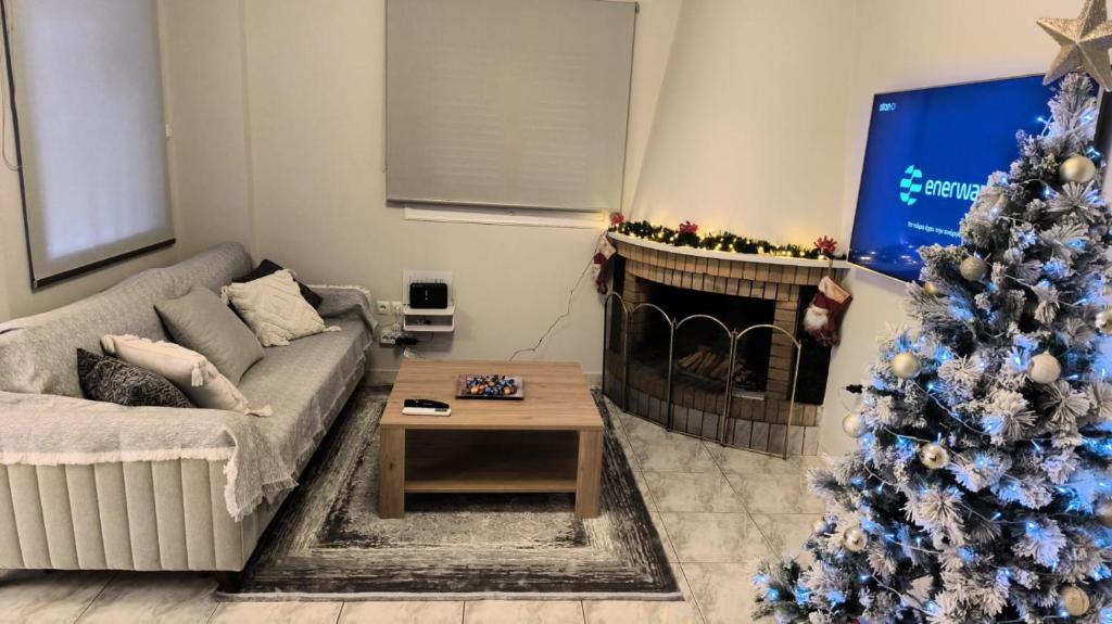 een woonkamer met een kerstboom en een bank bij ADRIANA'S House KARDAMYLI PROSILIO in Prosílion