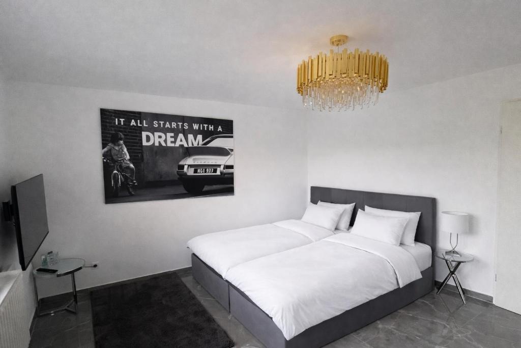 een slaapkamer met een wit bed en een kroonluchter bij Luxus-Flat Wohnung-Hanau/Frankfurt in Hanau am Main
