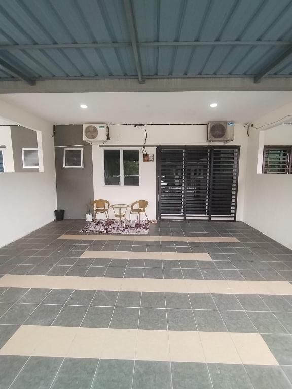 a room with two chairs and a table on a tiled floor at Ed 01 sitiawan homestay in Sitiawan