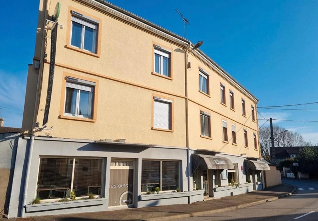 a large brick building with windows on a street at Aux Vendanges de Bourgogne in Paray-le-Monial
