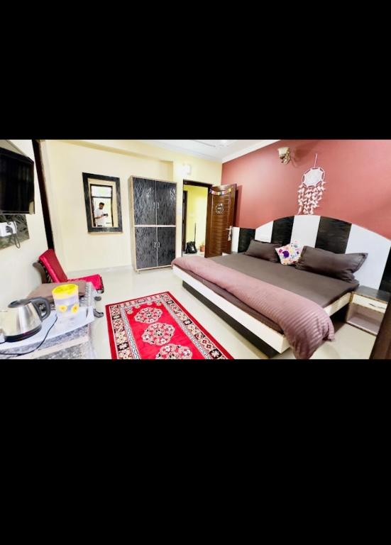 a bedroom with pink walls and a bed with a red rug at Green tree house in Dharmsāla