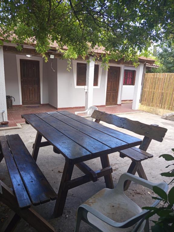 a wooden picnic table and a chair in front of a building at Forza e avanti in Santa Teresita