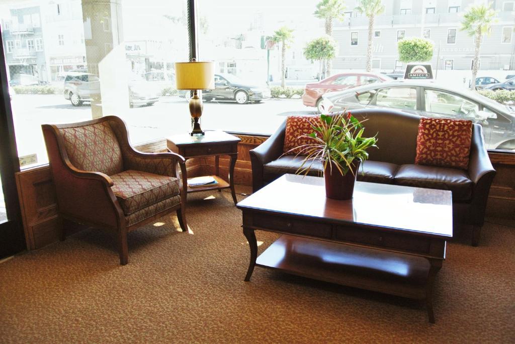 a living room with two chairs and a couch and a table at Cow Hollow Inn and Suites in San Francisco