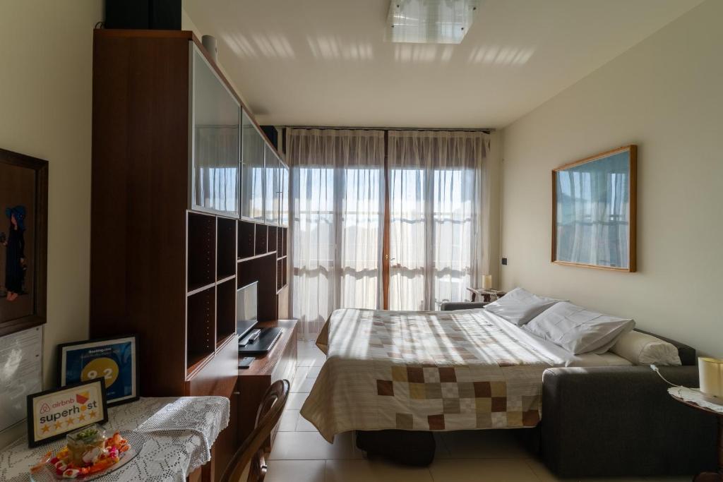 een slaapkamer met een bed, een bureau en een raam bij Suite Carpiano in Melegnano