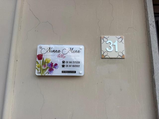 a sign on the side of a building with flowers on it at Casa Vacanze Nonna Mena in Fontechiari