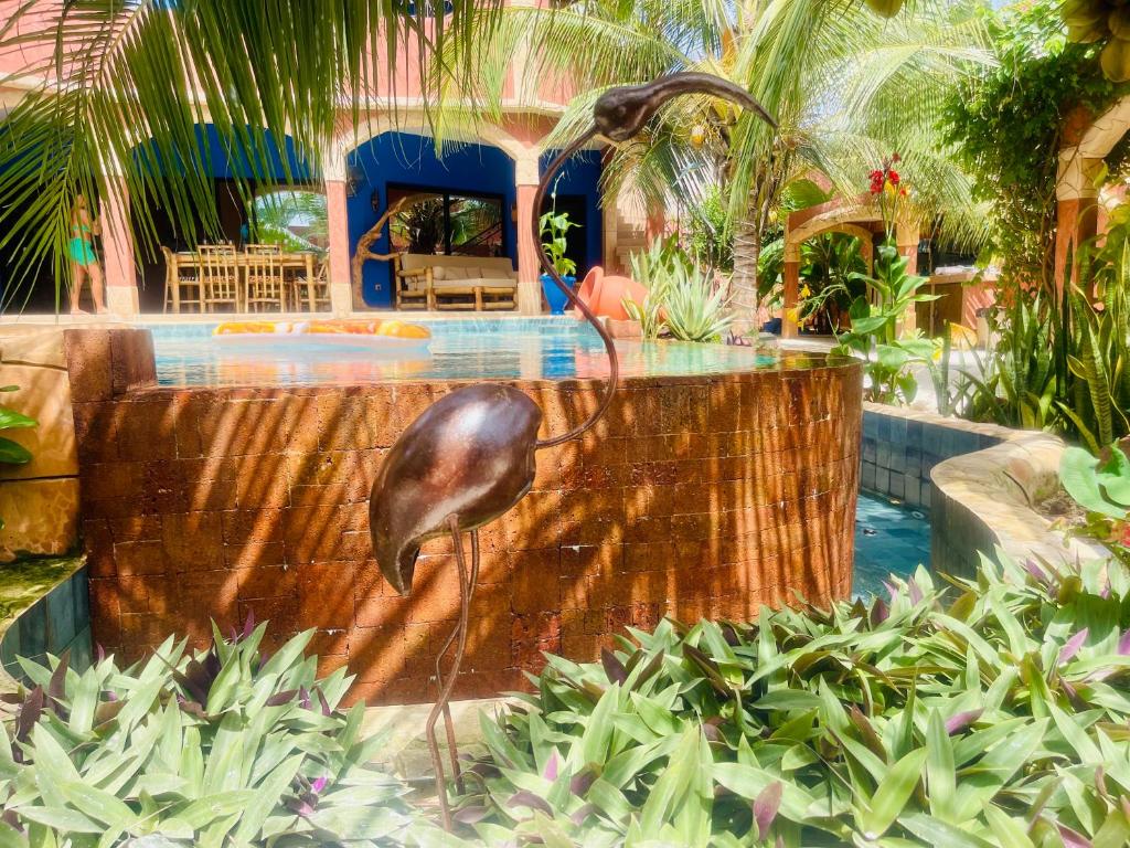 een fontein met een vogel in het midden van een tuin bij Téranga paradis in Somone