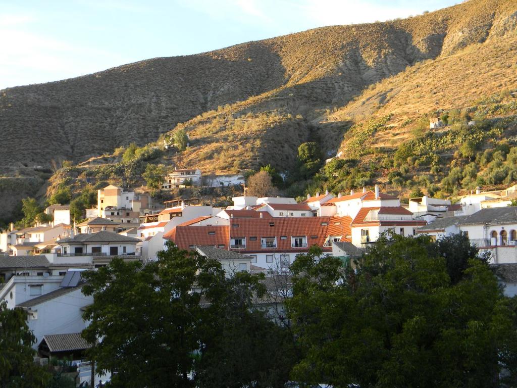 a town in front of a mountain with houses at Apartamento Granada Monachil II in Monachil