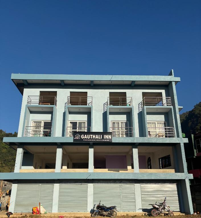 a building with two motorcycles parked in front of it at Gauthali Inn in Netadurling
