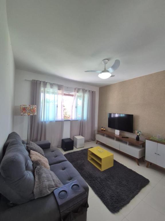 a living room with a couch and a flat screen tv at Elis Praia e Aconchego in Iguaba Grande