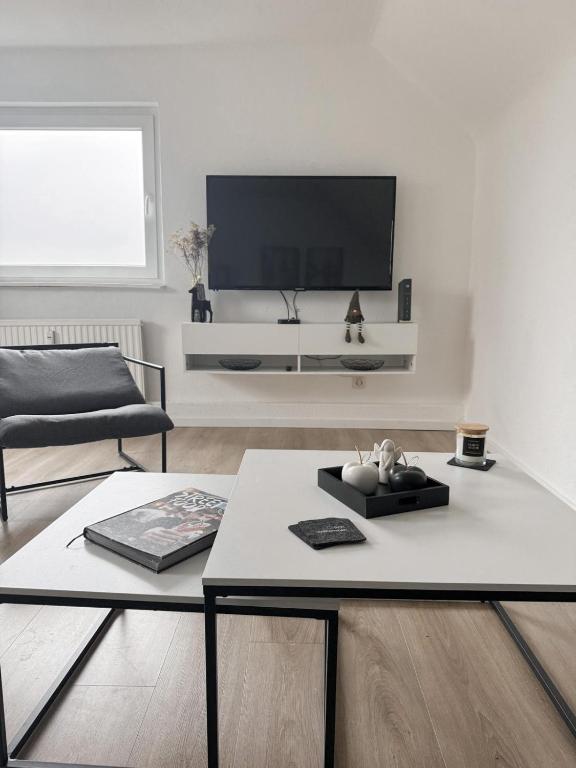 a living room with a tv on a white wall at Gemütliche Wohnung über den Dächern von Gevelsberg in Gevelsberg