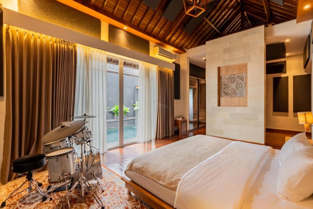 a bedroom with a bed with a drum set at Aresty 3 Bedroom Villa Canggu in Canggu