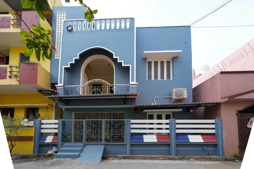 a blue building with a balcony on a street at Ashu Homestay Nest 1 in Pondicherry