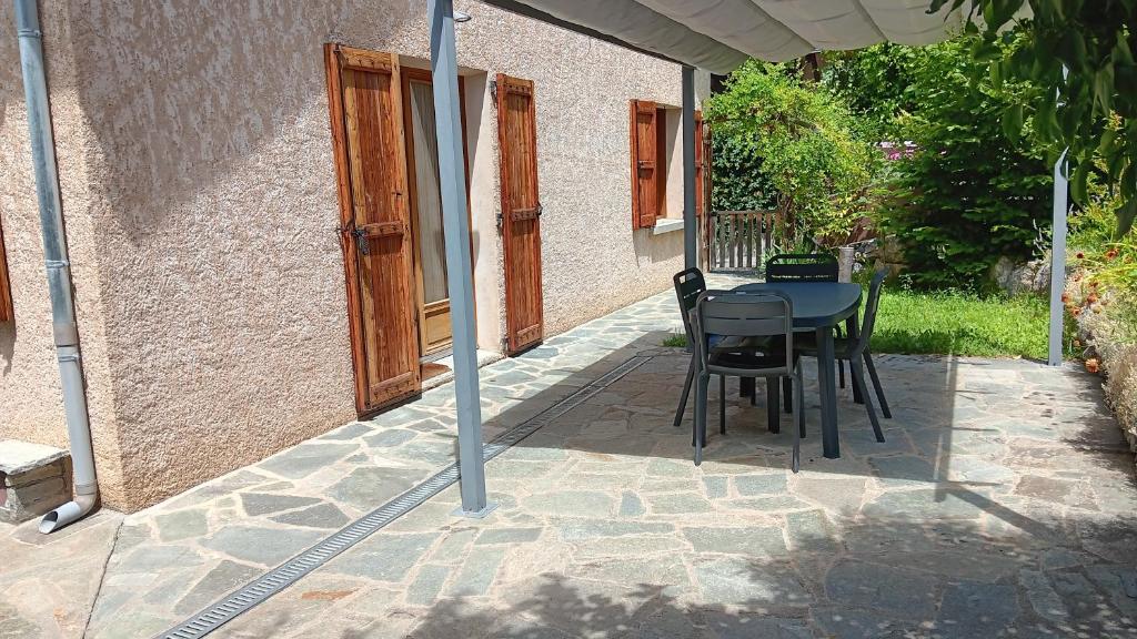 a table and chairs sitting on a patio at Rez de Jardin Guillestre in Guillestre