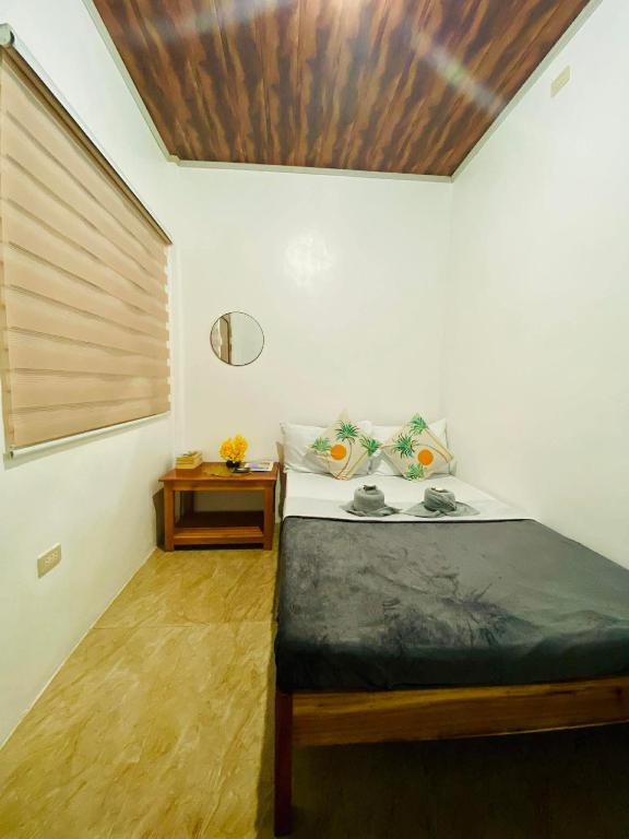 a bedroom with a bed with a wooden ceiling at Emmanuel2A Homestay in San Vicente