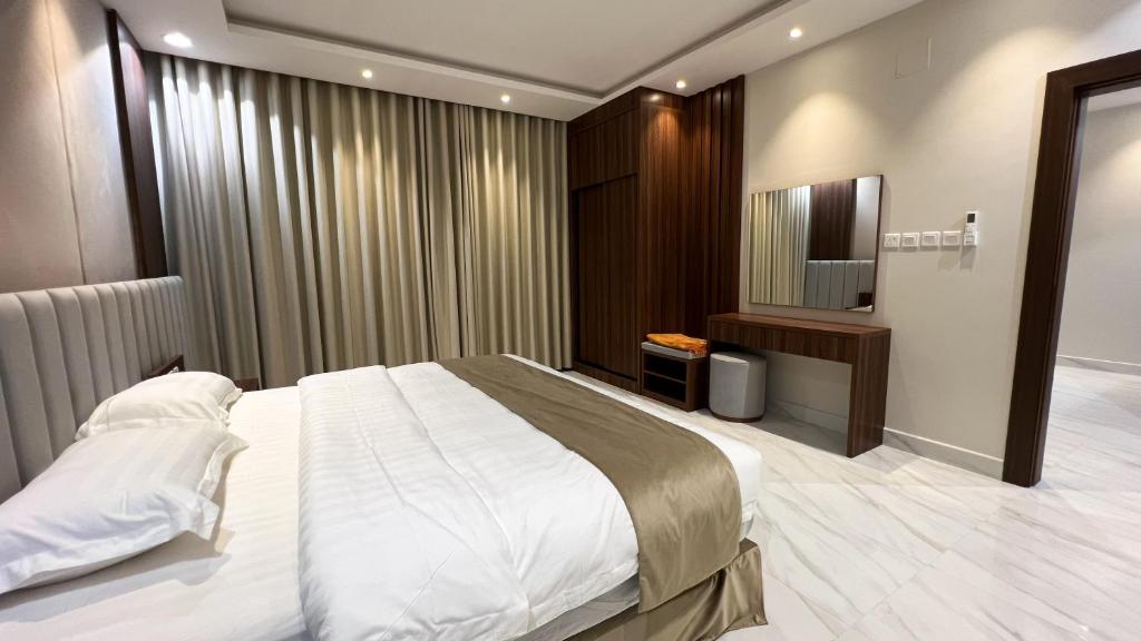 een slaapkamer met een groot bed en een televisie bij متسع للشقق المخدومة in Hail