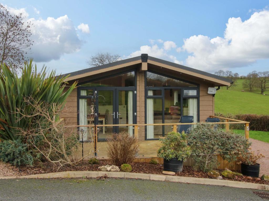 a small house with a large glass door at The Hedgerows - Hillview Lodges in Kidderminster