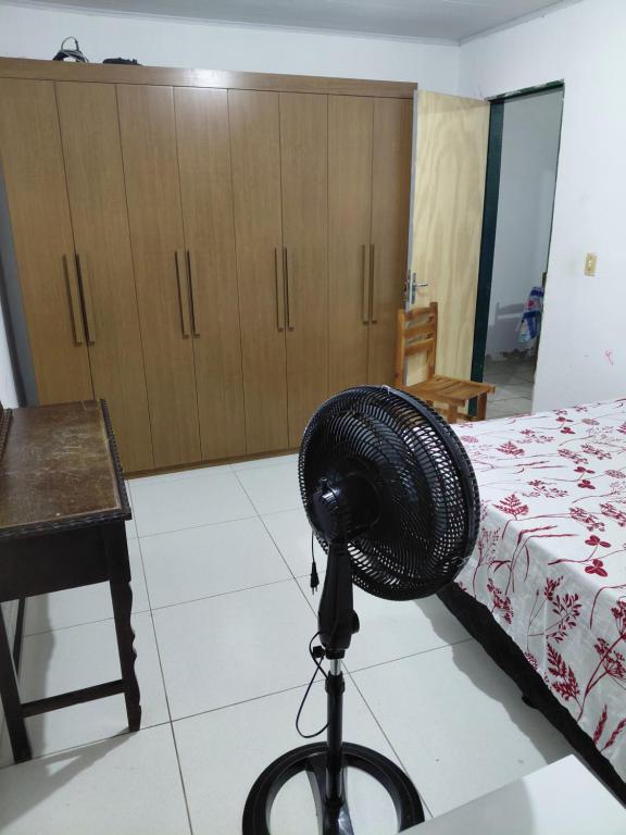 a hat on a tripod in a room with a bed at Casa Praça in Paripueira