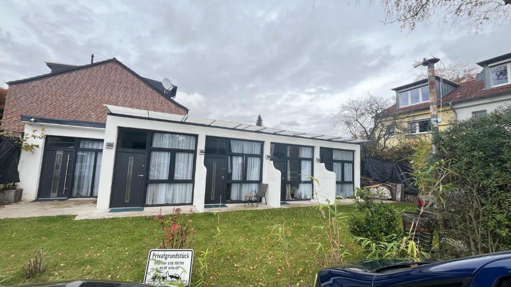 ein Haus mit schwarzen und weißen Fenstern und einem Hof in der Unterkunft Baadenbergerstay B in Köln