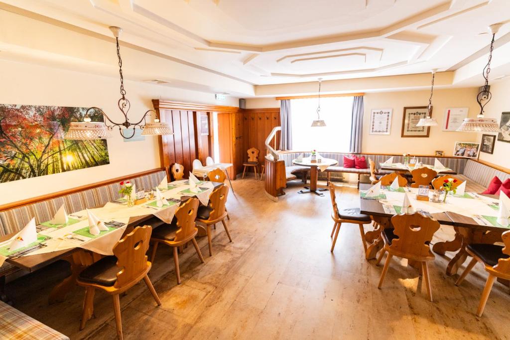 een restaurant met houten vloeren en tafels en stoelen bij Schöckllandhof in Eggersdorf bei Graz