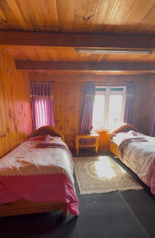 a bedroom with two beds and a window at Everest hotel in Phāphlu