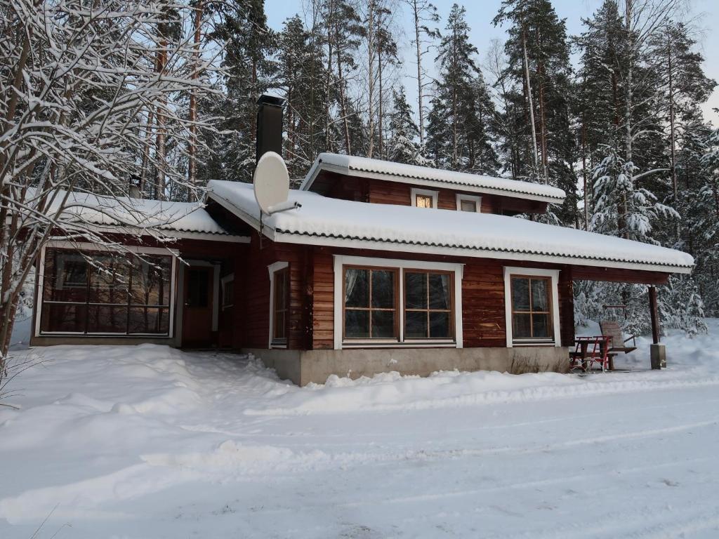 een blokhut met sneeuw op de grond ervoor bij Mökki Syrjälä in Puumala