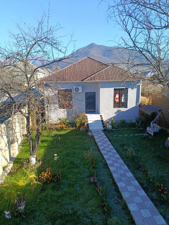 a house with a grass yard with a house at Villa Gabala in Gabala